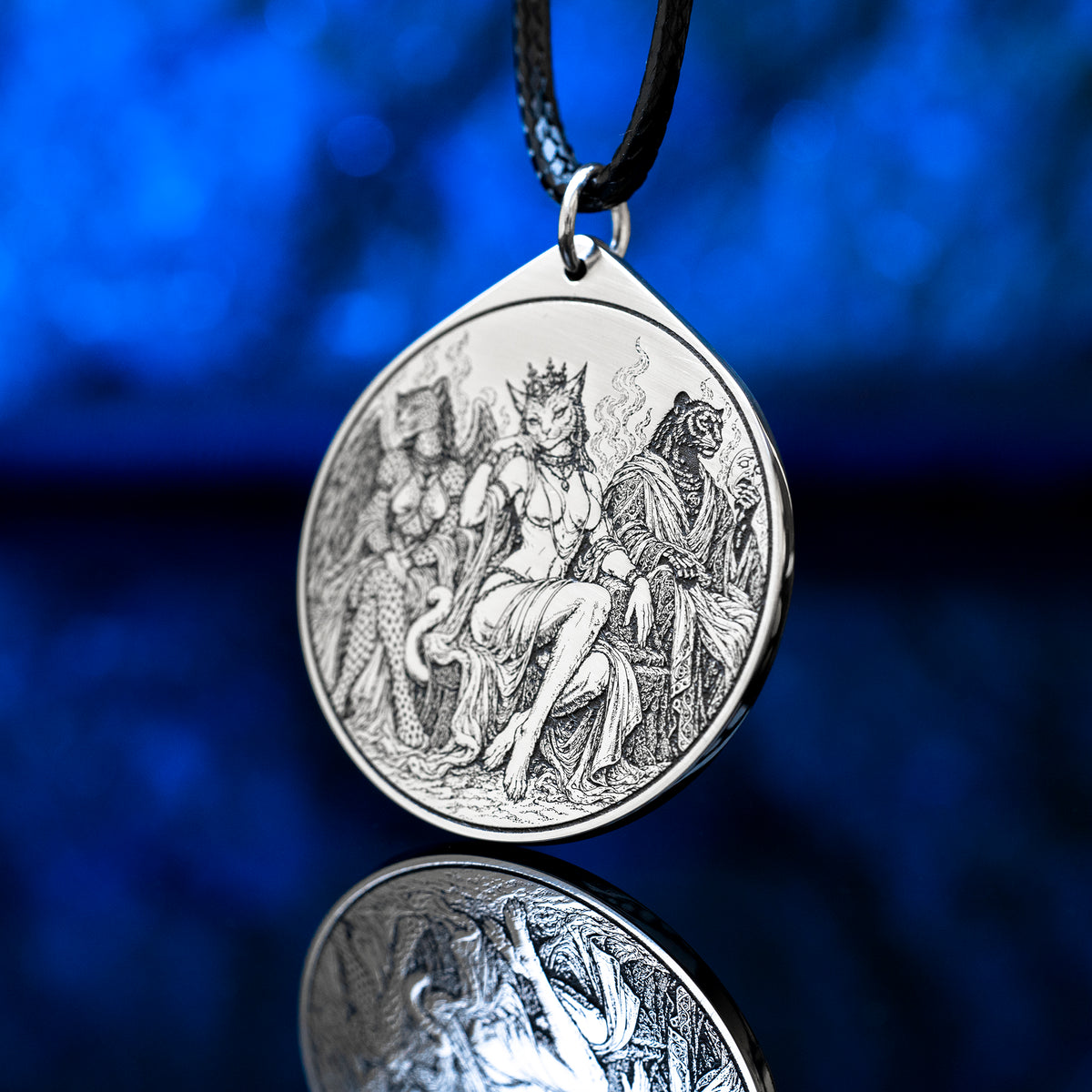 Feline Goetic Trinity pendant featuring detailed engravings of Sitri, Ose and Beleth as feline demons. Silver-tone occult necklace with Ars Goetia artwork on a black cord against a deep blue background.