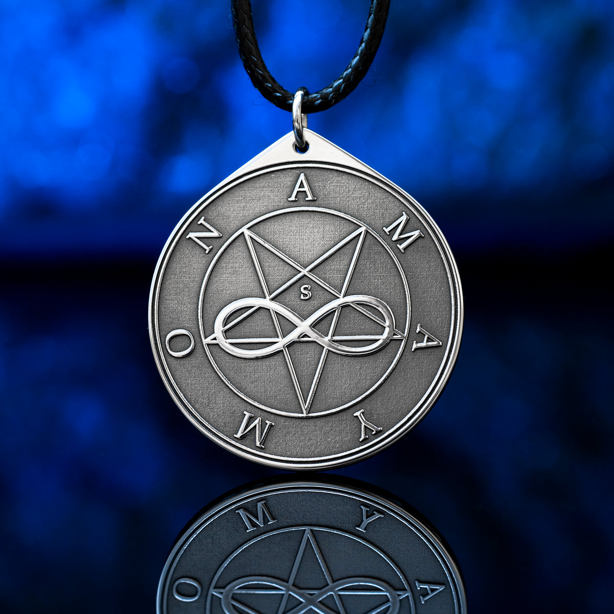 Amaymon Seal Pendant featuring an engraved inverted pentagram, intertwined infinity symbol and Amaymon lettering. Round silver tone occult medallion on a black braided cord, photographed against a deep blue background with a reflection
