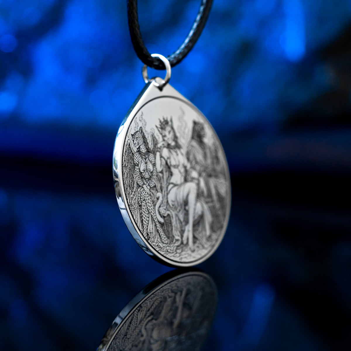 Feline Goetic Trinity pendant featuring detailed engravings of Sitri, Ose and Beleth as feline demons. Silver-tone occult necklace with Ars Goetia artwork on a black cord against a deep blue background.